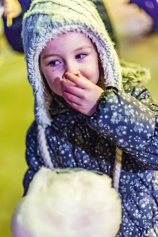 快乐的年轻女孩吃仙女棉花糖