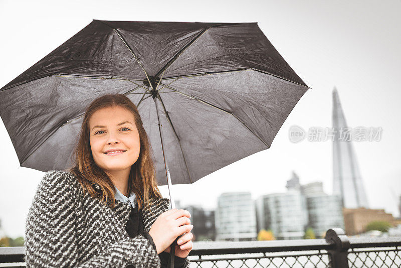 幸福女人在伦敦拿着伞