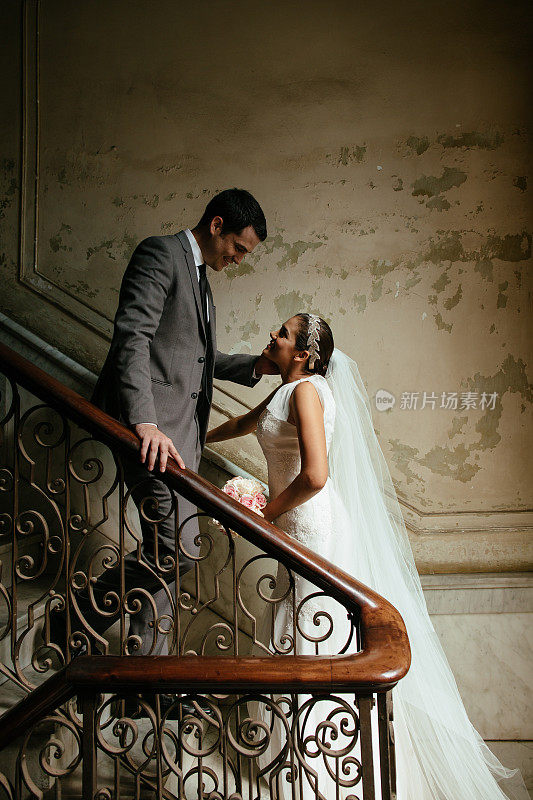 浪漫的西班牙新婚夫妇在楼梯上互相看着