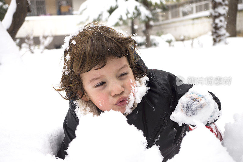 小男孩在冬天玩雪