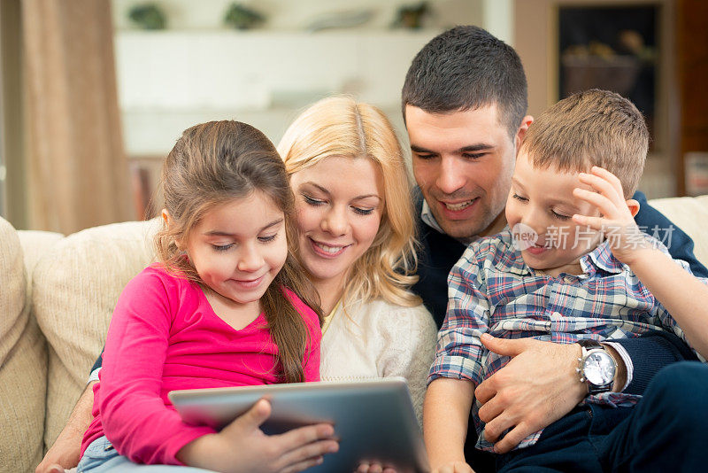 快乐的家庭玩数字平板电脑的肖像