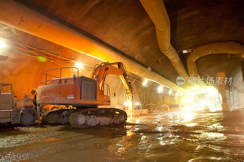 混凝土隧道施工中的橙色液压挖掘机