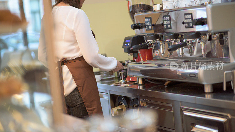 女服务员用咖啡机煮咖啡