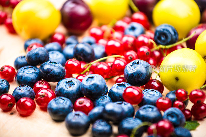 蓝莓，红醋栗，浆果，不同的水果在木制的背景