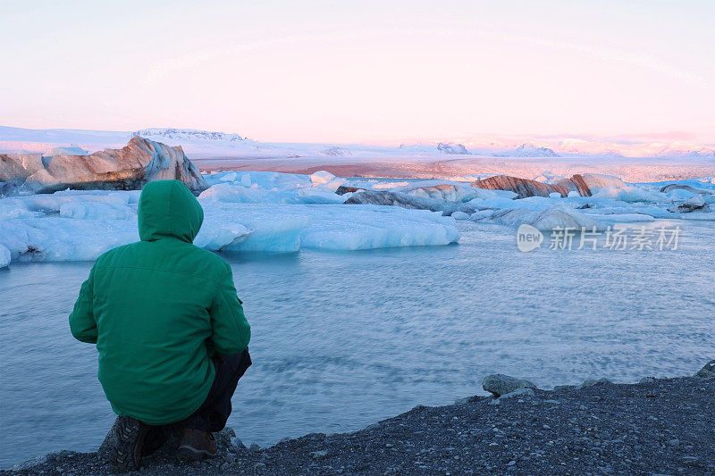 冰岛的Jokulsarlon冰川泻湖上，徒步旅行者正在欣赏日出