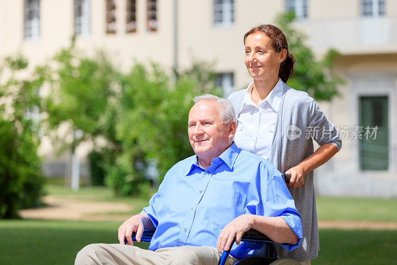 老人和护工坐在轮椅上
