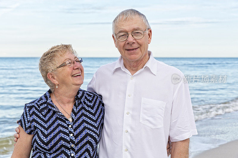 两位老人在海滩享受退休生活