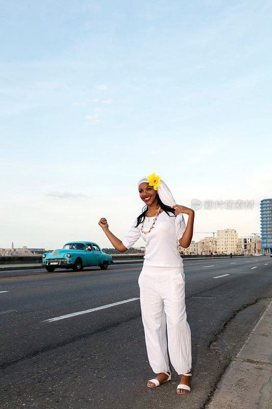在古巴哈瓦那，一位年轻漂亮的古巴妇女在叫出租车