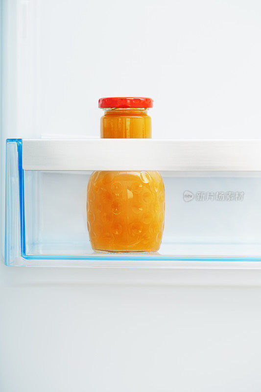 冰箱架子上的橙汁瓶