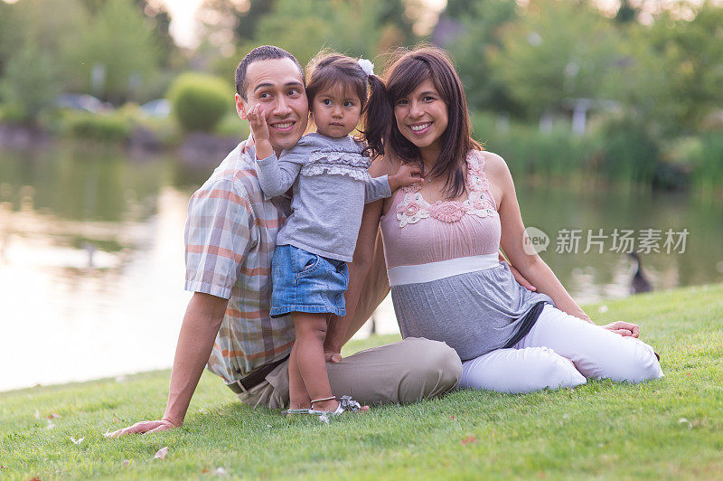 怀孕的夏威夷夫妇和年幼的女儿在户外公园