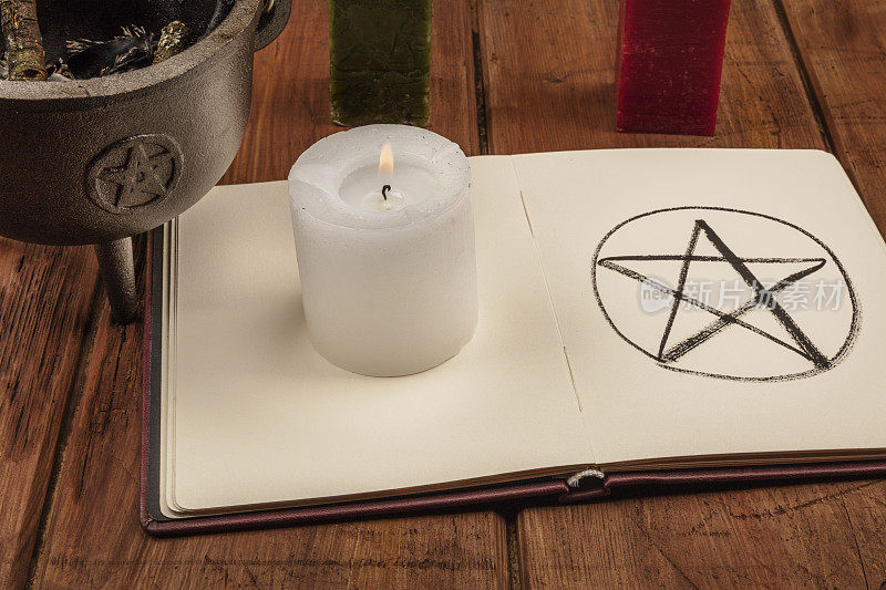 一张蜡烛的照片，一个女巫的坩埚，还有一本阴影书里的五角星