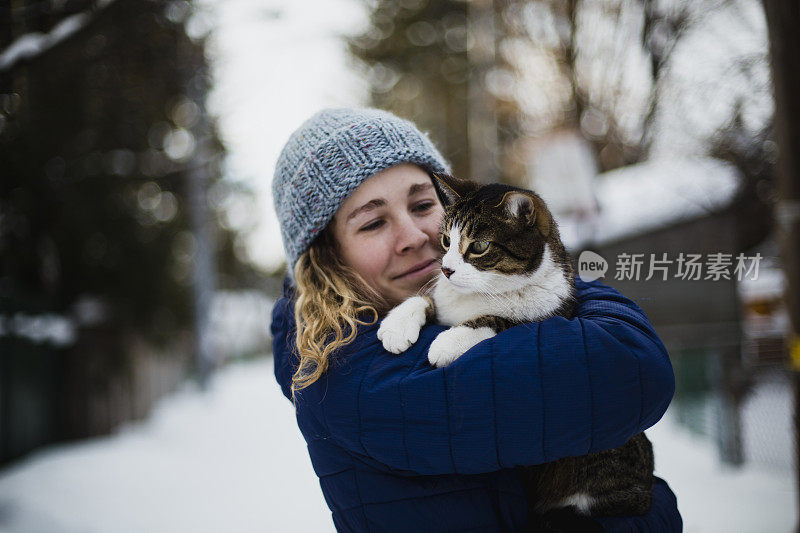 一个年轻女人在室外抱着她的猫