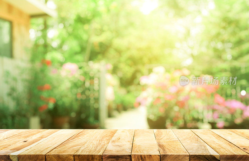 空的木质桌面模糊抽象的绿色从花园和房子的背景