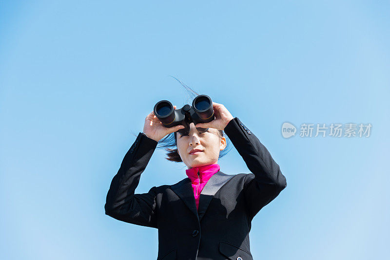 女商人用双筒望远镜看风景