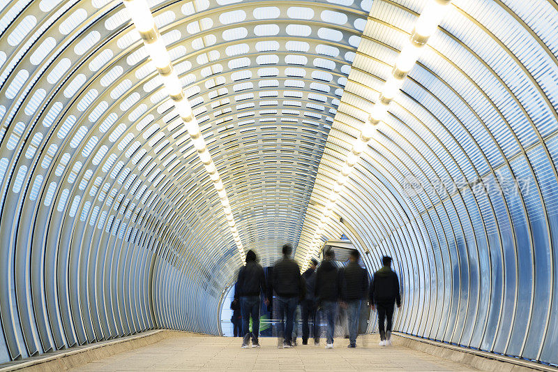 模糊的通勤者在伦敦的现代隧道里穿梭