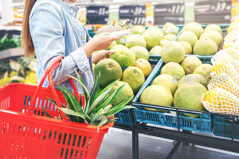 亚洲女性在超市购买健康食品蔬菜和水果