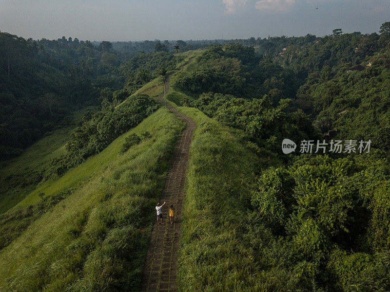 无人机的观点，年轻夫妇走在大米自然散步，乌布-巴厘岛-人们旅游热带目的地爱浪漫的概念