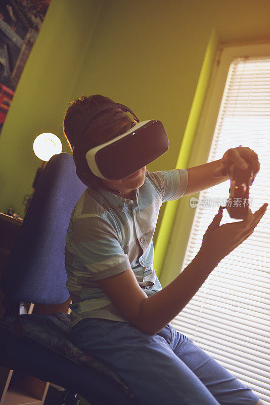男孩戴着VR眼镜玩游戏手柄