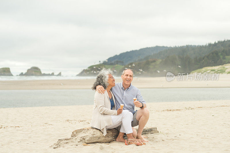 一对老年夫妇在海滩上一起享用甜筒冰淇淋