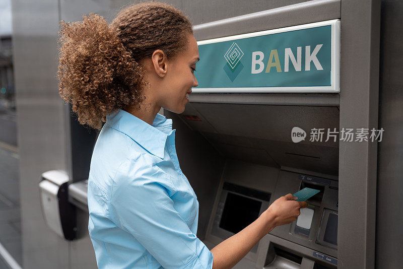 一个非裔美国女人在自动取款机上取款
