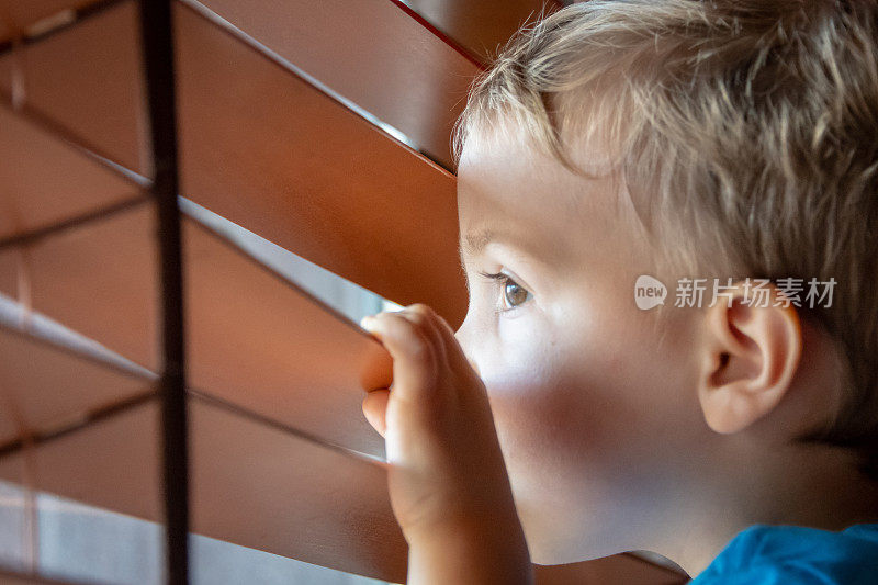 一个三岁的小男孩往窗外看