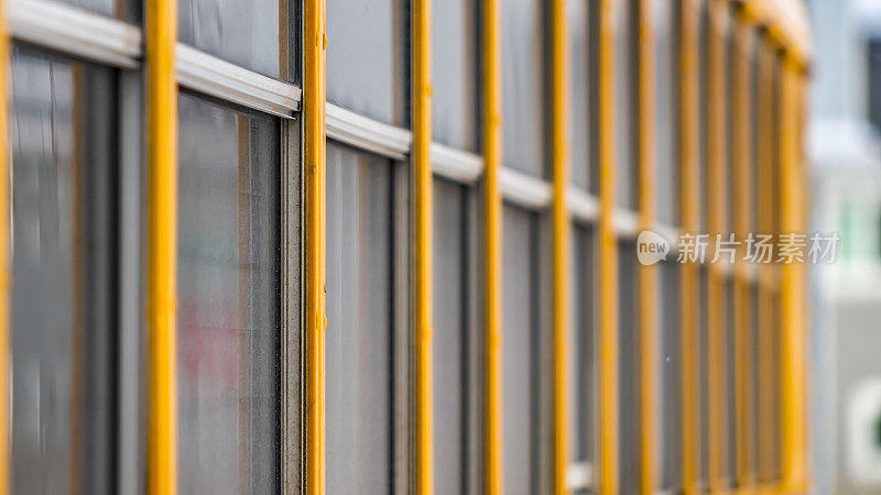 全景:一辆黄色校车的外观，靠近玻璃窗