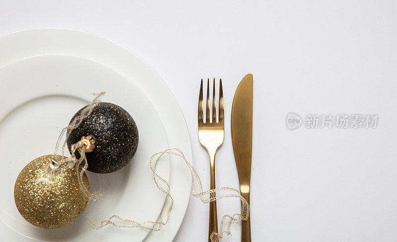 餐桌摆设，圣诞，新年。白色餐具上的金色餐具，白色背景