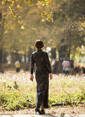 秋天走在树林里的中国妇女穿着传统的中国服装