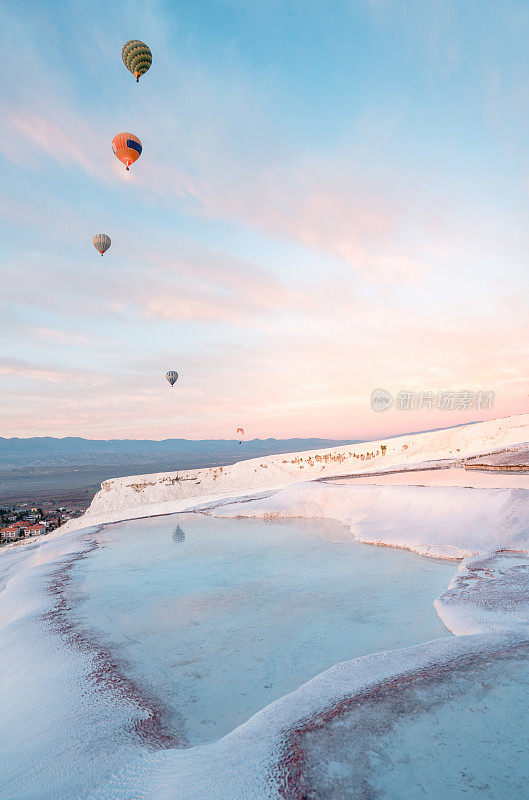 丹尼兹利Pamukkale，日出时石灰华池、石灰石梯田中的热气球