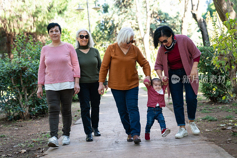 年长和成熟的成年妇女照顾可爱的婴儿学步