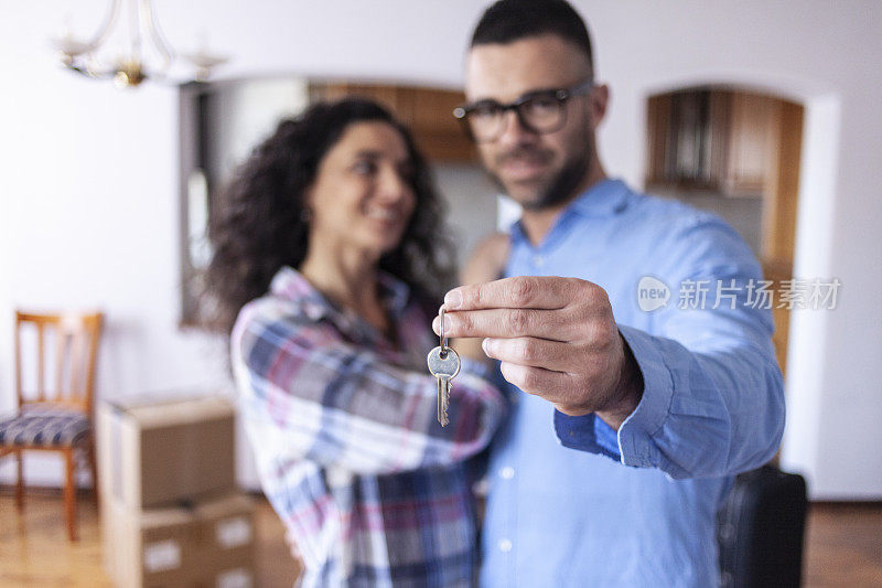 年轻夫妇拿着新公寓的钥匙