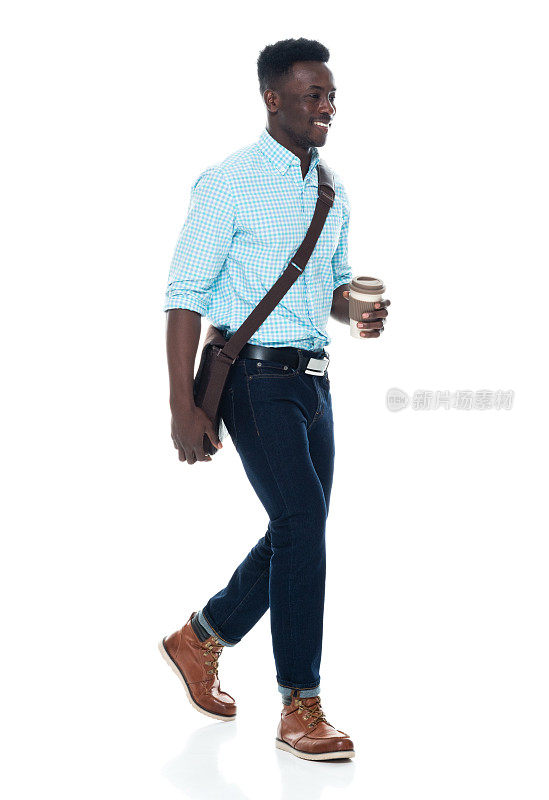 非裔美国男性，肩包，手拿咖啡杯，走在白人背景前