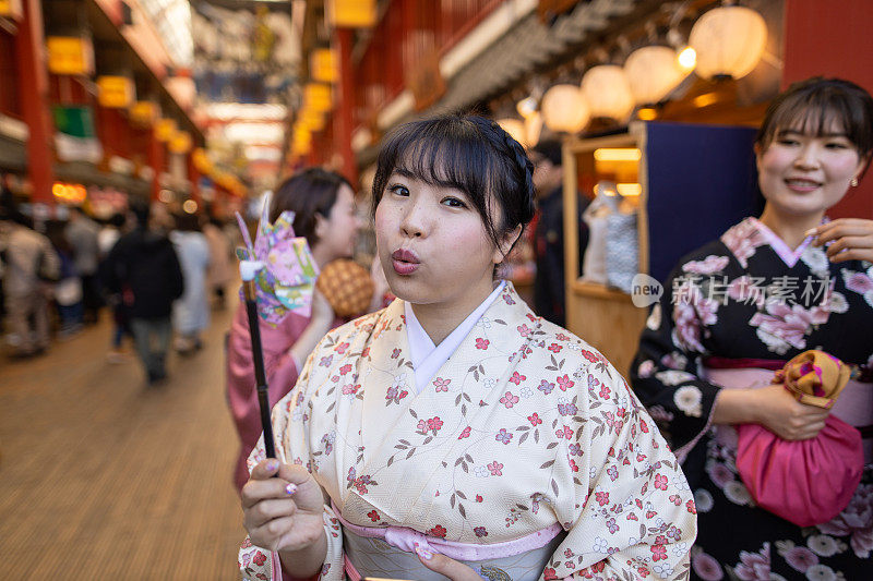 穿着和服的日本妇女在购物中心吹风车