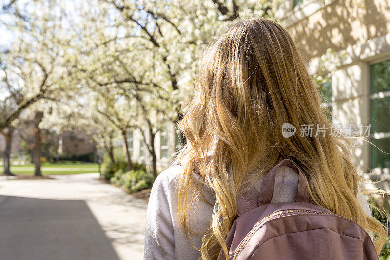 春天里漫步在大学校园里的女学生