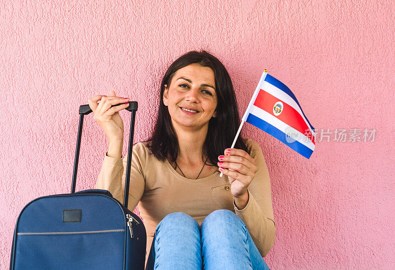拿着旅行袋和哥斯达黎加国旗的女人