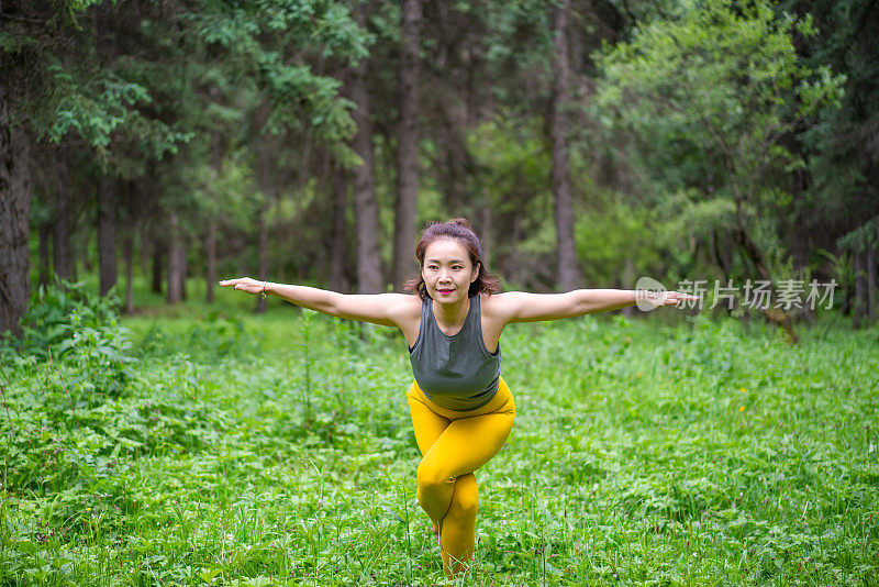 年轻的亚洲女人在森林里练习瑜伽