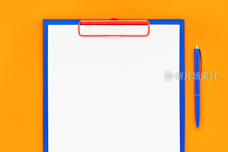 空白剪贴板模型和蓝色钢笔在橙色背景。俯视图，复制空间。回到学校，截止日期，早上的概念。