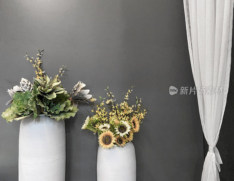 窗帘旁边放着两大盆花。