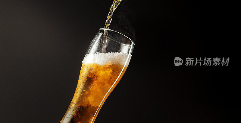 将冰凉清爽的啤酒倒进有泡沫的玻璃中，水平放置