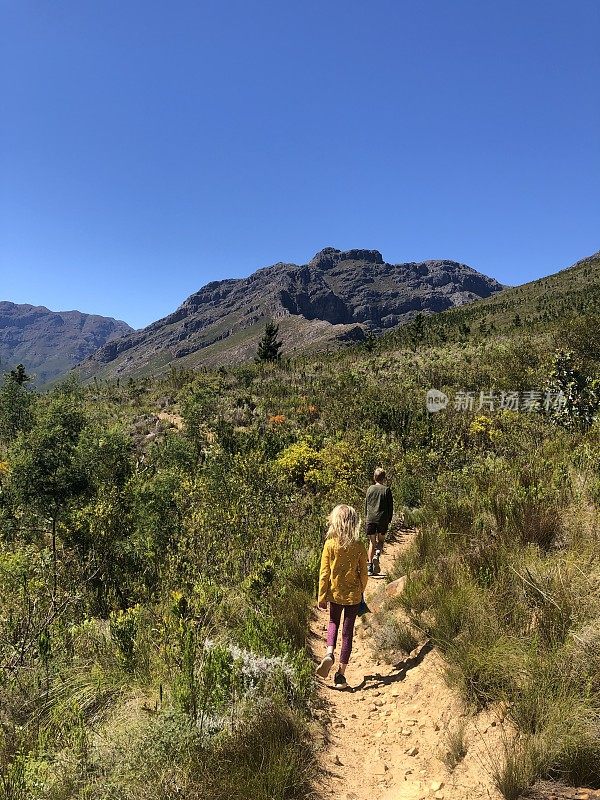 两个孩子在峡谷之间的一条小路上徒步旅行