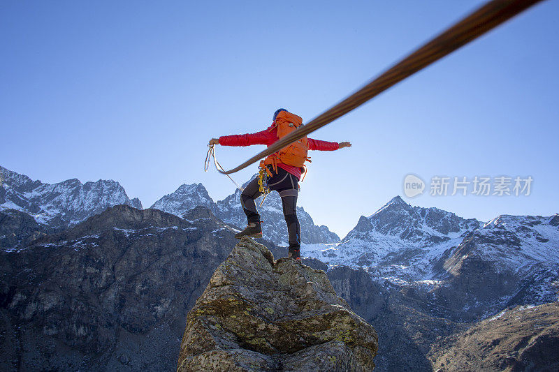 一个登山家登上了顶峰，伸开双臂