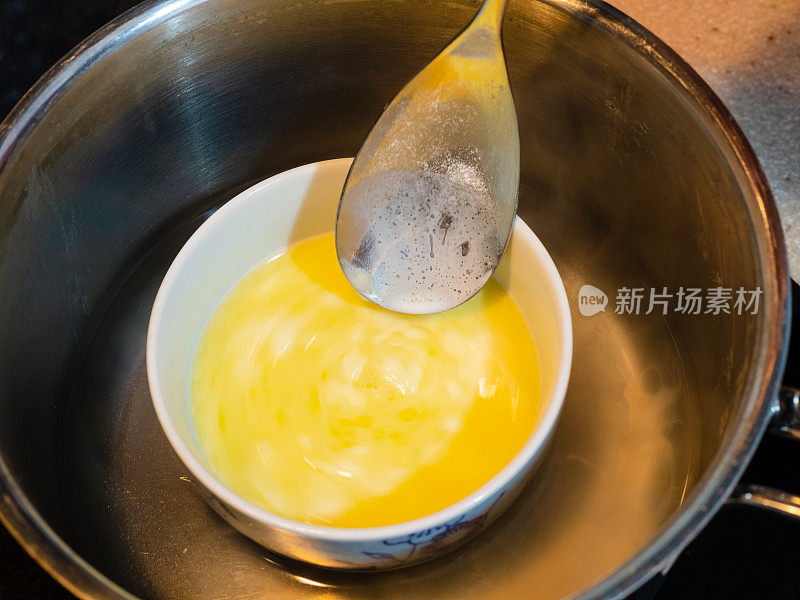 黄油在碗中融化，用水浴
