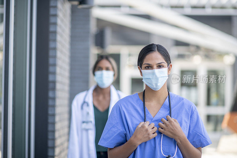 女医科学生，穿着医用消毒服和面罩