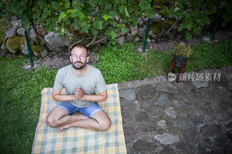 一个男人在后院做瑜伽。