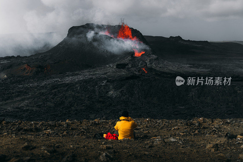 在冰岛的法格达尔斯火山喷发时，游客们感到敬畏