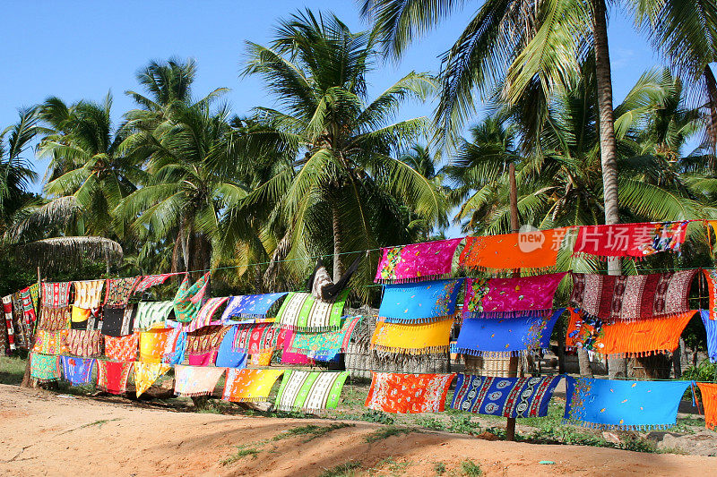 五彩缤纷的纱笼悬挂在非正式市场的椰子树下