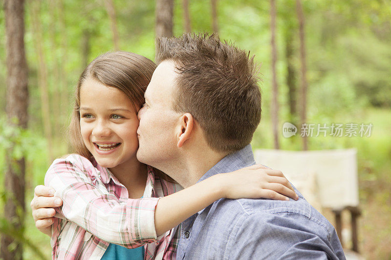 父亲在户外给女儿甜蜜的吻。父母,孩子。爱情,亲情。