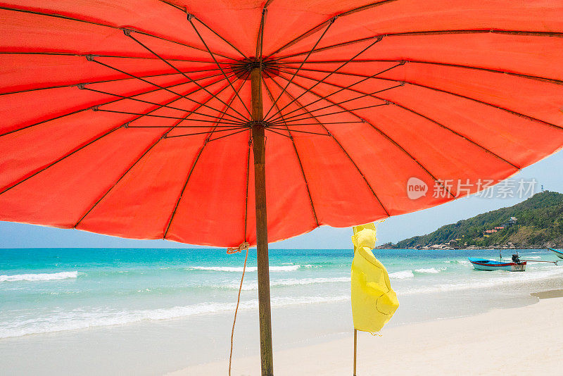 在哈德林海滩的红色遮阳伞下