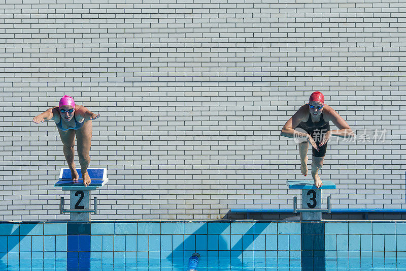 正面的两个年轻的女游泳运动员开始比赛