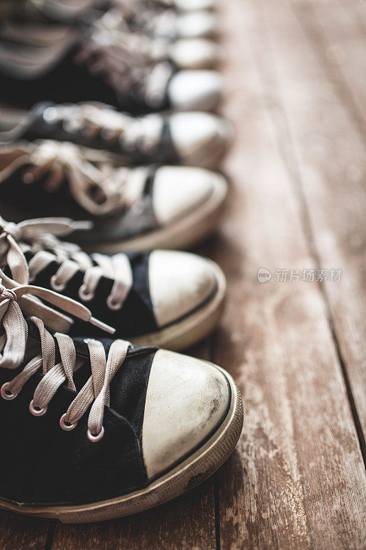 帆布鞋在木地板上排成一排